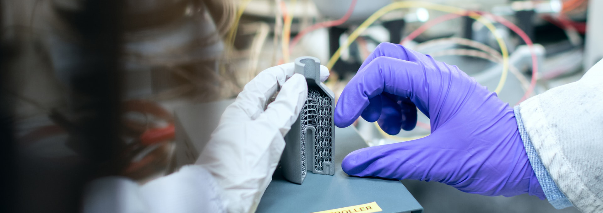 gloved hands holding metal device